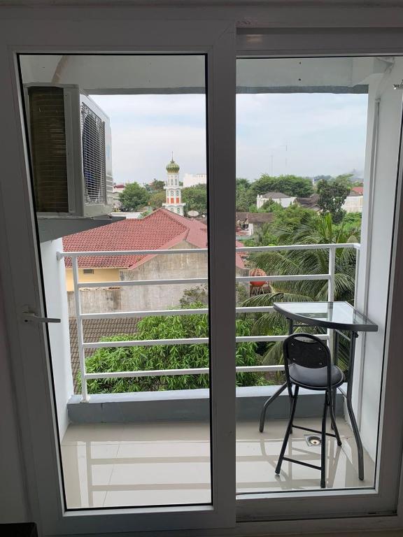 einen Balkon mit einem Stuhl und einem Tisch in der Unterkunft Mansyur Residence Apartment Medan in Sunggal