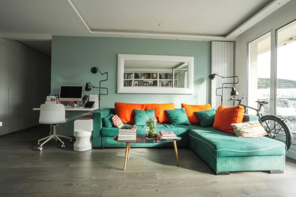 uma sala de estar com um sofá verde e almofadas laranja em 16th District Spacious Sophistication em Montreuil