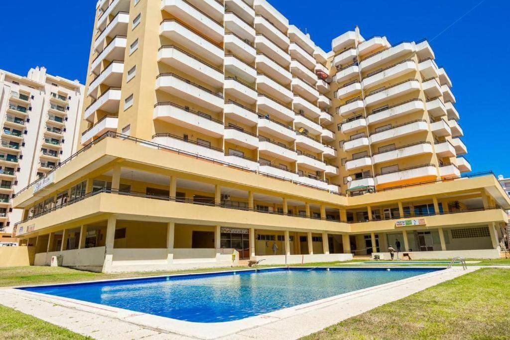 - un grand bâtiment avec une piscine en face dans l'établissement Sweet Home Casa dos Arcos 409, à Portimão