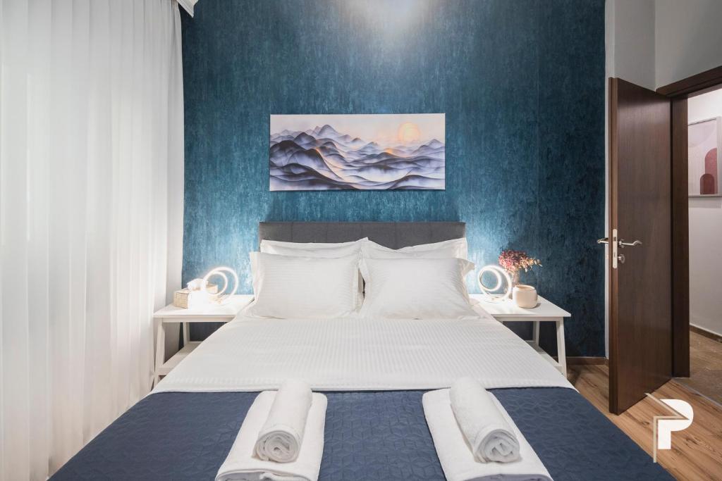 Schlafzimmer mit einem Bett mit blauer Wand in der Unterkunft P deluxe suites 4 in Thessaloniki