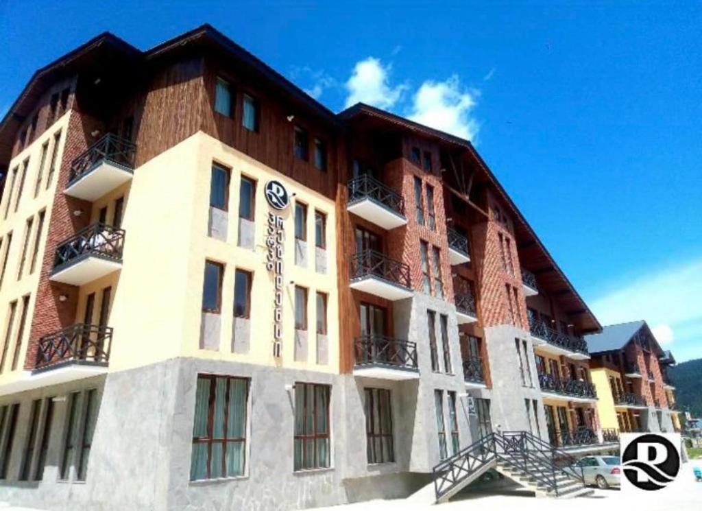 a large brick building with windows and balconies at Bakuriani Park Recidence Apartment in Bakuriani