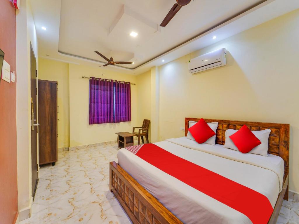 a bedroom with a large bed with red pillows at Moonlight Stays in Chennai