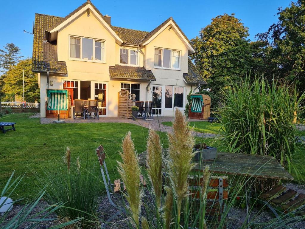 a yellow house with a table in the yard at Doppelhaushaelfte-Klatschmohn in Presen