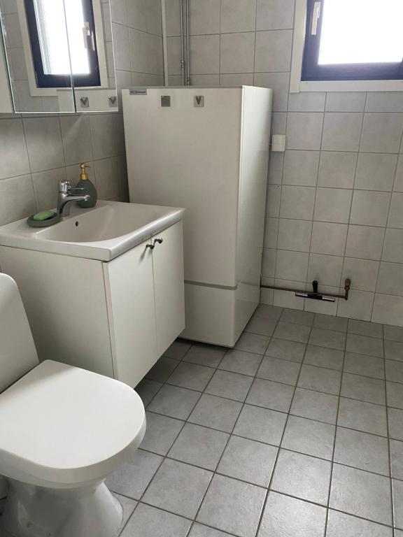 bagno con servizi igienici, lavandino e frigorifero. di Eget hus i Vittjärv a Boden