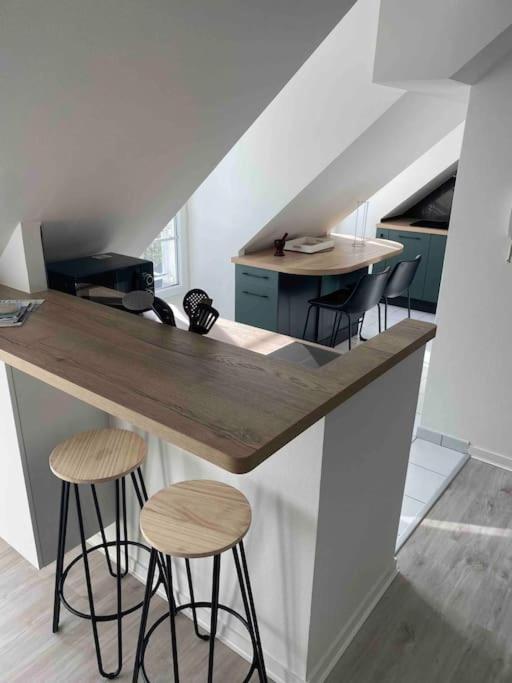 eine Küche mit zwei Hockern an einer Theke in einem Zimmer in der Unterkunft Bel appartement 4 personnes in Port-en-Bessin-Huppain