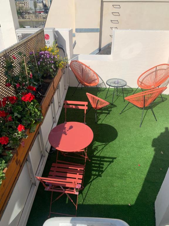 a balcony with red tables and chairs and flowers at VUE SUR LA SEINE in Paris