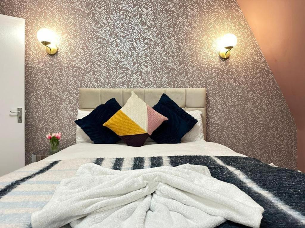 a bedroom with a white bed with colorful pillows at Three Bedroom Near London Eye in London