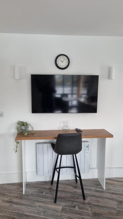 a desk with a chair and a clock on a wall at 1 main street athlone in Athlone