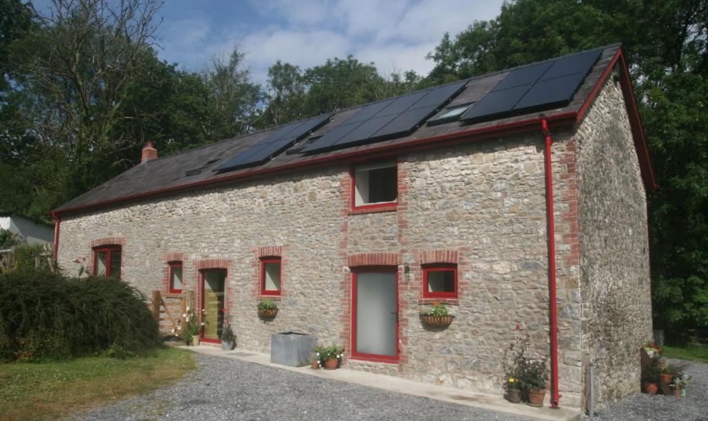 uma casa com painéis solares no telhado em Creatively converted barn in accessible rural spot em Llanwrda