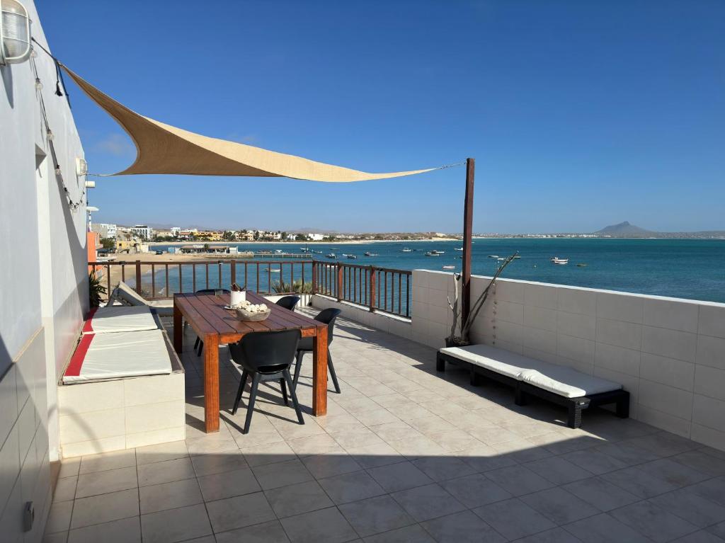 a balcony with a table and chairs and the ocean at Casa Tud Dret - sea front apartments in Sal Rei