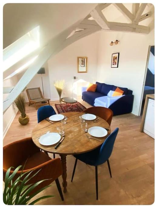 un salon avec une table et un canapé bleu dans l'établissement Le flamboyant, à Angers