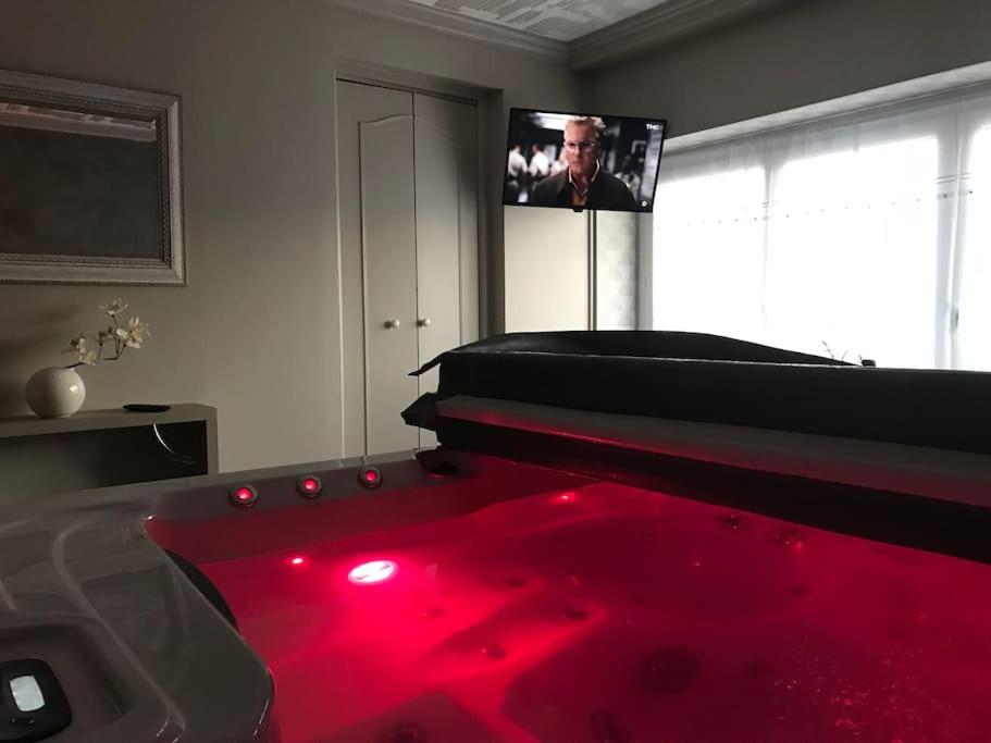 a room with a bed and a tv in it at MAISON AVEC JACUZZI PRIVATIF in Cambrai