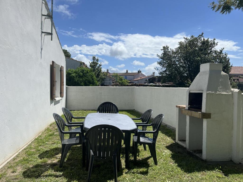 - une table et des chaises dans l'arrière-cour d'une maison dans l'établissement Vacances reposantes a Oleron, au Château-dʼOléron