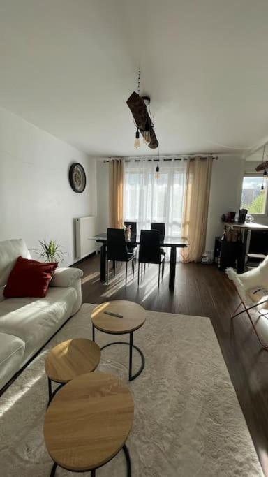 un salon avec un canapé, des chaises et une table dans l'établissement Appartement entier Paris/Disney, à Champs-sur-Marne