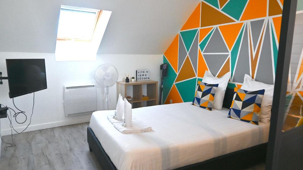 um quarto com uma cama grande e uma parede colorida em COCOONING Appartement 10mn Aeroport Roissy CDG em Villeneuve-sous-Dammartin