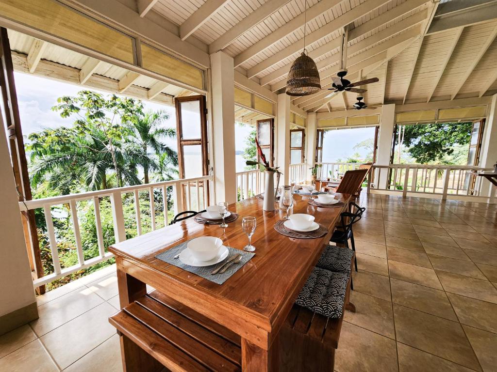 a dining room with a long wooden table with chairs at Tropical Paradise, Oceanfront Home in the Jungle in Bocas del Toro