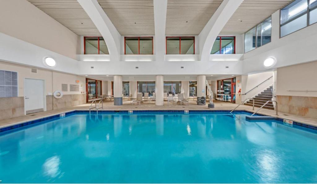 duży basen z niebieską wodą w budynku w obiekcie Embassy Suites by Hilton Boston Waltham w mieście Waltham