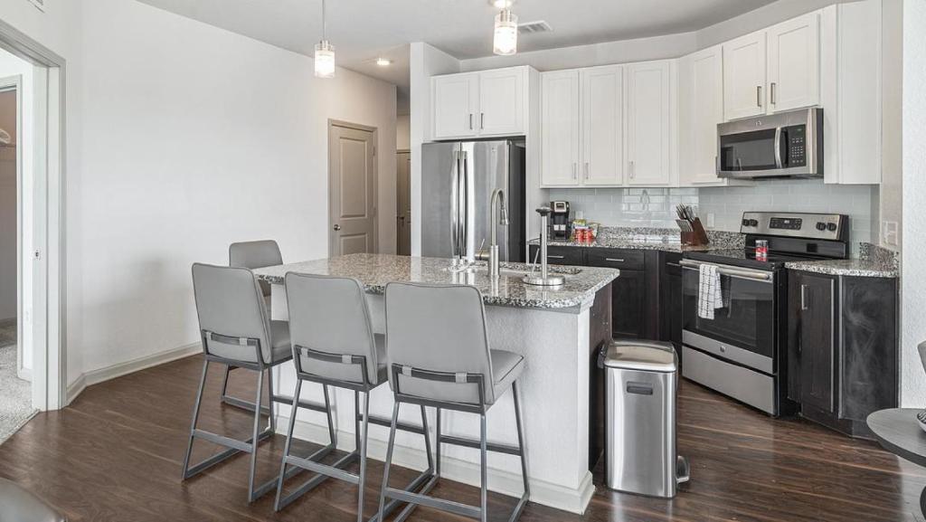 a kitchen with a island with bar stools at Landing at eXchange - 1 Bedroom in Downtown Detroit in Detroit