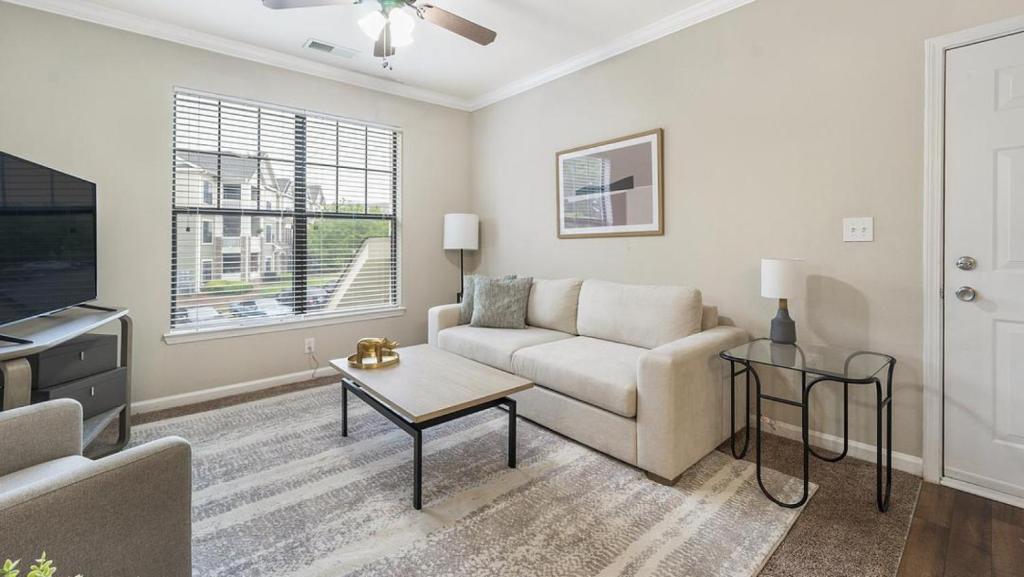 a living room with a couch and a tv at Landing at Crescent Park Commons - 1 Bedroom in Greer in Greer