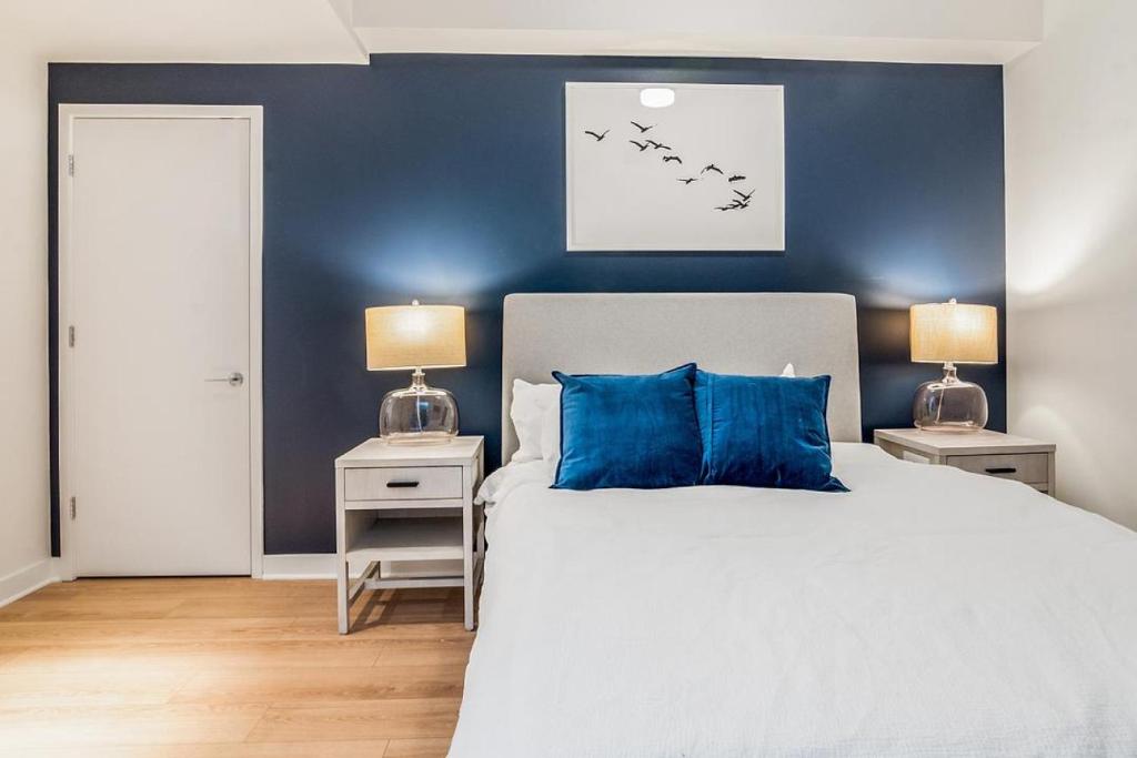 a bedroom with a blue wall and a bed with blue pillows at Landing at Logan Apartments - 2 Bedrooms in Logan Square in Chicago