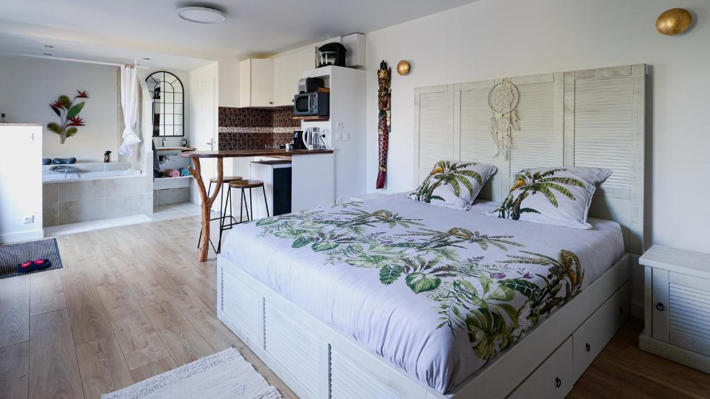 Il comprend une chambre avec un grand lit et une cuisine. dans l'établissement Maisonnette cosy bord de Seine 30min paris, à Carrières-sous-Poissy