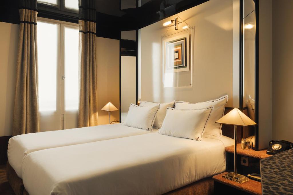 Habitación de hotel con cama grande con almohadas blancas en Hôtel Château d'Eau, en París