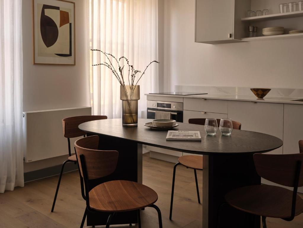 a kitchen with a table with chairs and a vase with flowers at The Marloes in London