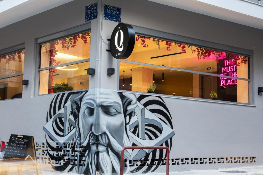 un edificio con una cara pintada en el costado. en The Q Hotel, en Atenas