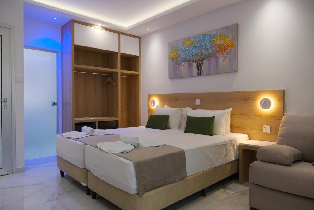 a bedroom with a large bed and a chair at Loutsiana Deluxe Apts in Ayia Napa