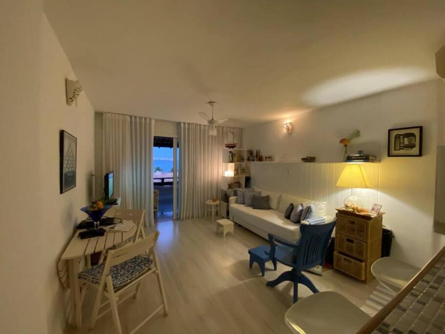 - un salon avec un canapé, une table et un bureau dans l'établissement Flat aconchegante à beira-mar, à Vera Cruz de Itaparica