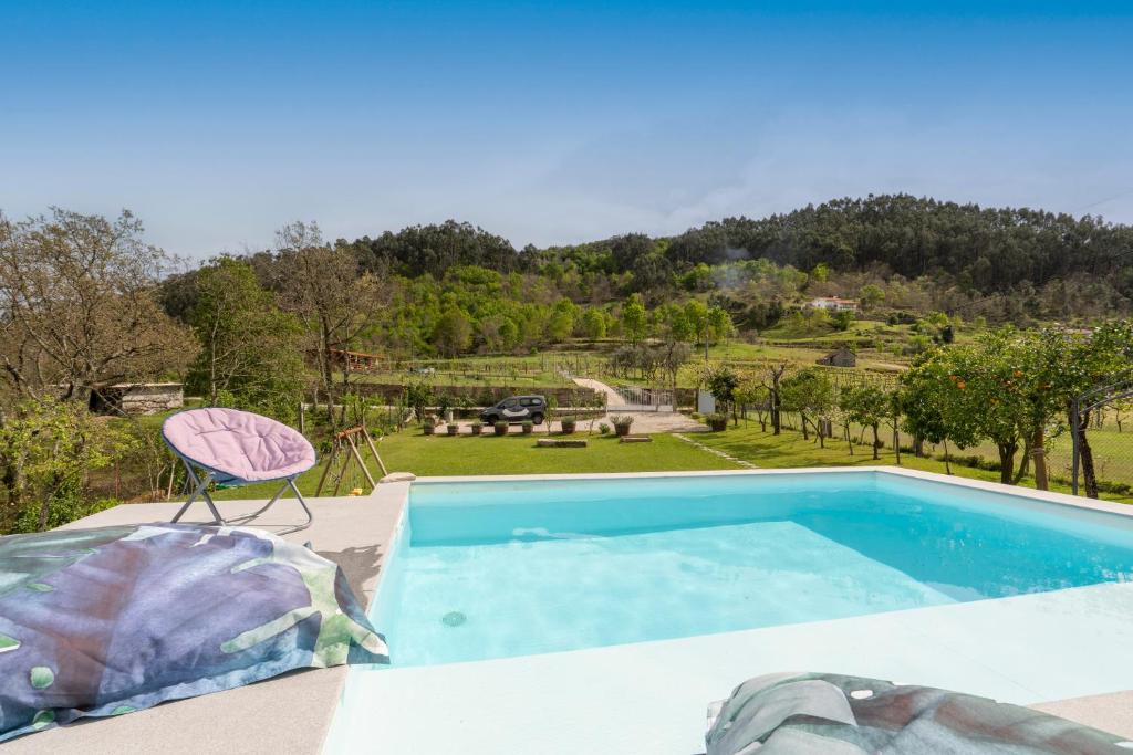 a villa with a swimming pool and a chair at Host Wise - Spacious Comfortable House Pool in Amarante