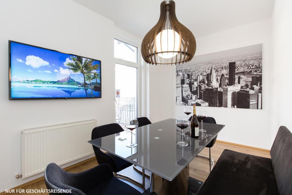 a dining room with a glass table and chairs at INNSBRUCK CENTER APARTMENTS tirol in Innsbruck