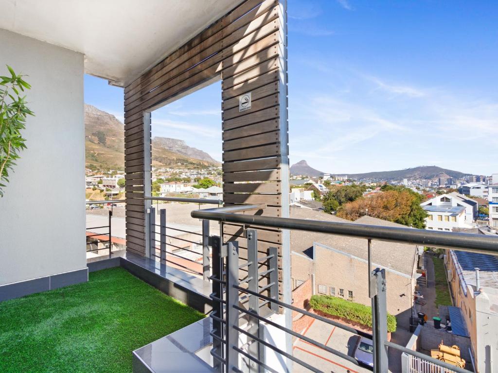 a balcony with green grass and a view of a city at Upper East Side 407 in Cape Town