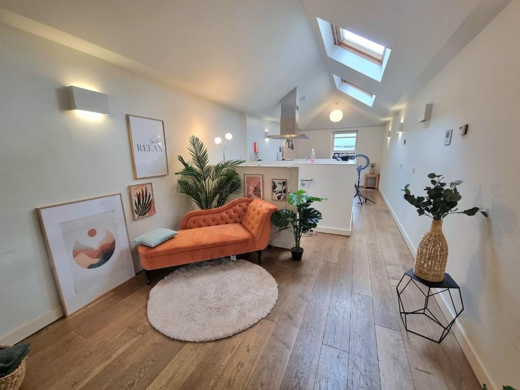 a living room with an orange couch and a table at London City Apartments in London