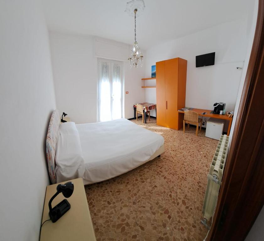 um quarto com uma cama, uma secretária e uma mesa em B & B di Massimo C em Spotorno