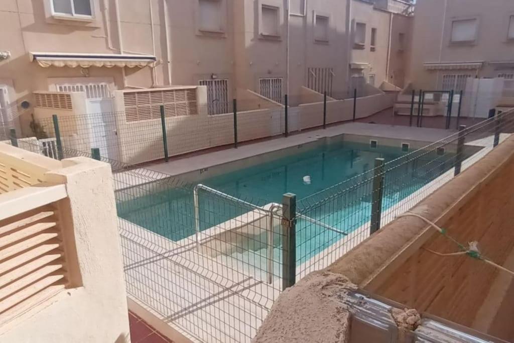 a swimming pool with a fence around it at adosado con piscina en Cabo de Gata 4p in El Cabo de Gata