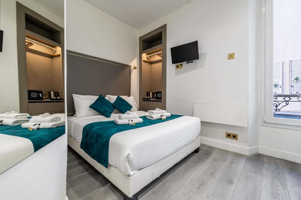 - une chambre d'hôtel avec 2 lits et des serviettes dans l'établissement Hotel Avaton - 1 min du Palais - Cannes Centre, à Cannes