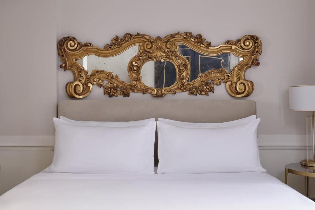 a bedroom with a bed with a mirror above it at Violino d&#39;Oro Venezia in Venice