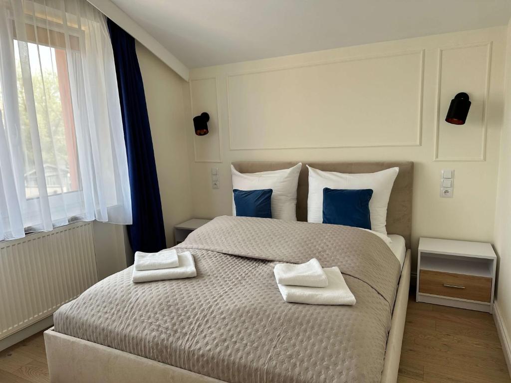 1 dormitorio con 1 cama grande con almohadas azules en Go Mazury, en Mrągowo
