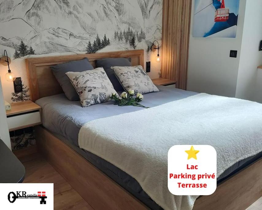 a bed in a bedroom with a sign that sayslag parking privateerate at Sublime Studio proche du lac avec parking privé in Viviers-du-Lac