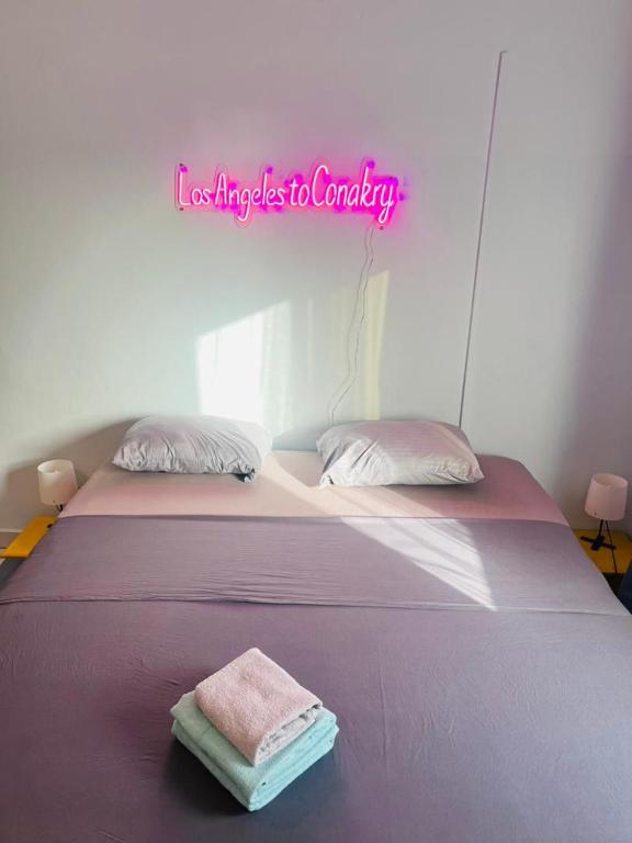 Una cama con dos toallas en una habitación en Los Angeles to Conakry *KIPE*, en Conakry