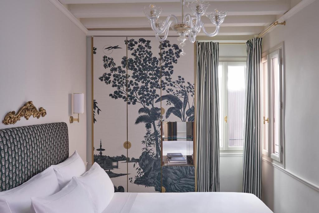 a bedroom with a bed and a chandelier at Violino d&#39;Oro Venezia in Venice