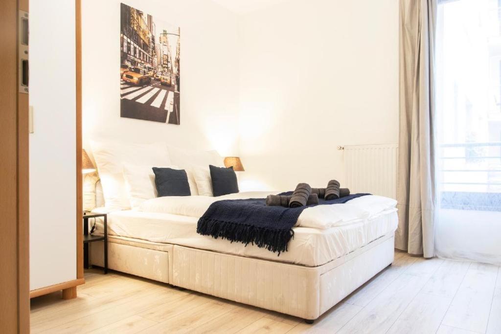 a white bedroom with a bed and a couch at Budapest Opera Apartment in Budapest