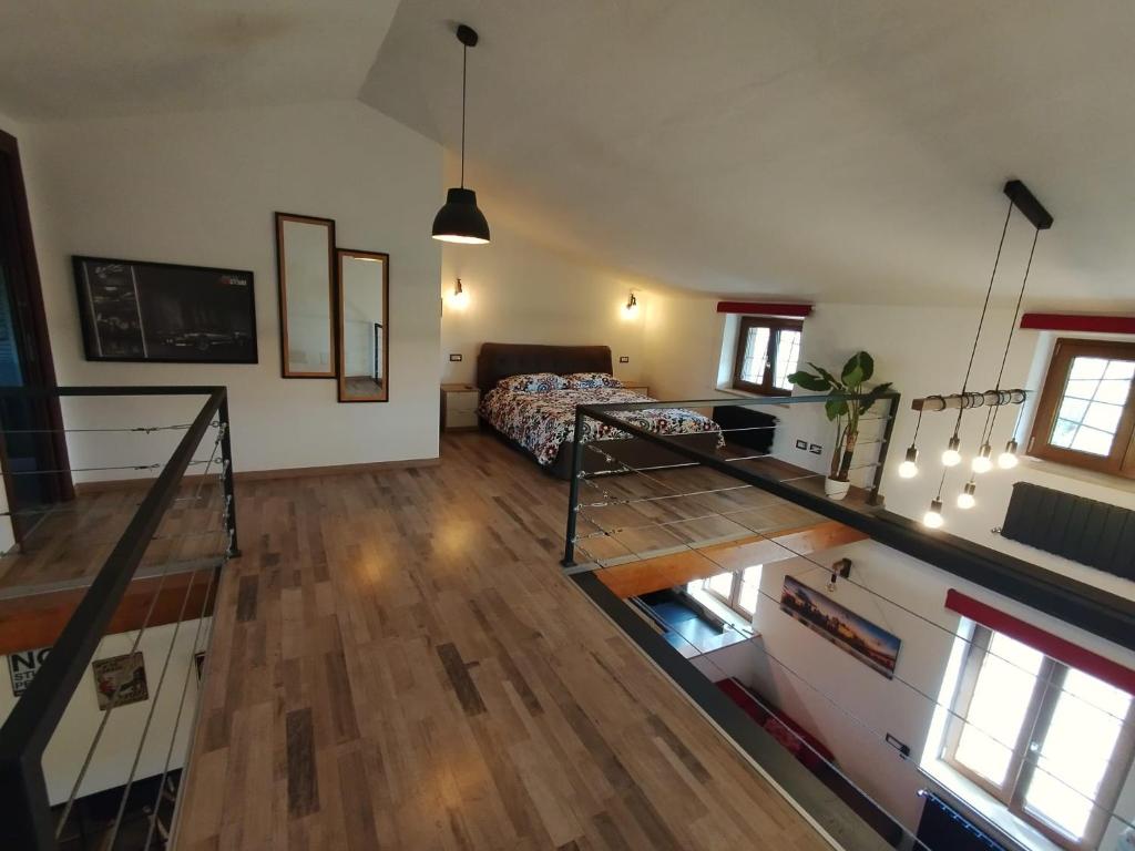 una gran sala de estar con cama y suelo de madera. en Loft americano in villa, en Aprilia