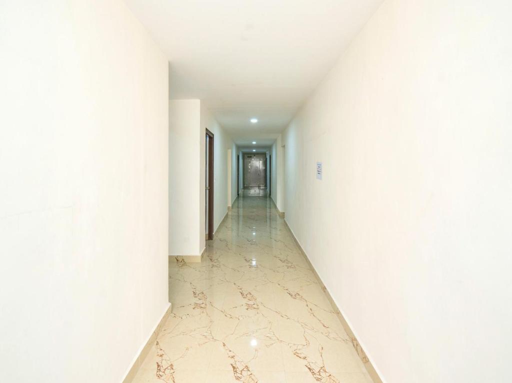 an empty hallway with white walls and a marble floor at Townhouse Hotel Rio in Hyderabad