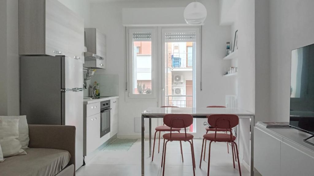 une cuisine avec une table et trois chaises rouges dans l'établissement CUORE DI ANNA, à Pesaro
