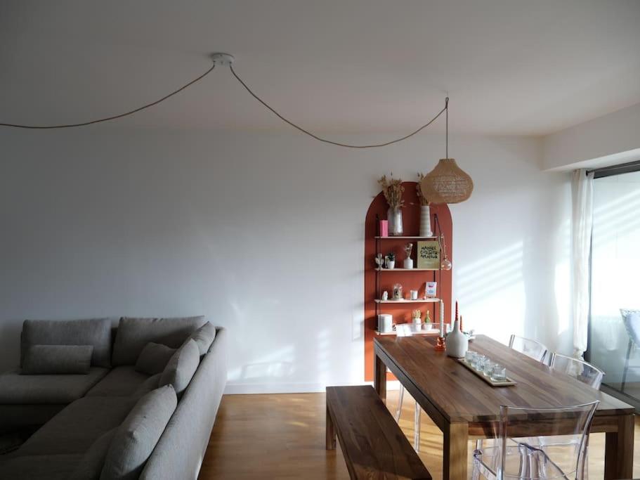 uma sala de estar com um sofá e uma mesa em Appartement 4pax : Parking, balcon, climatisation. em Boulogne-Billancourt
