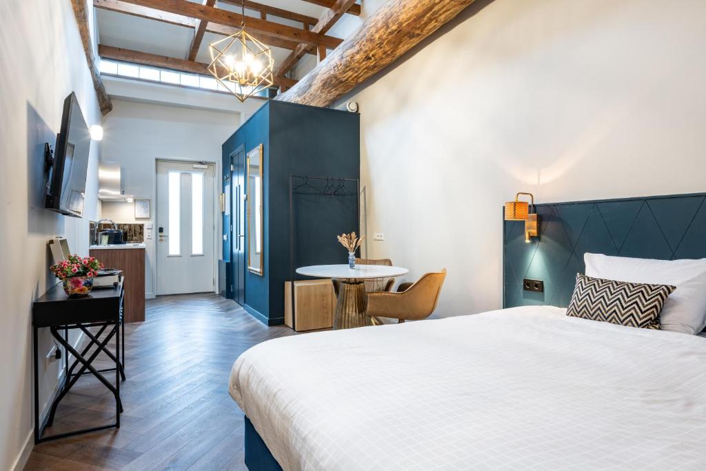 Un dormitorio con una cama grande y una mesa. en Grapèlli Boutique Hotel, en Alkmaar