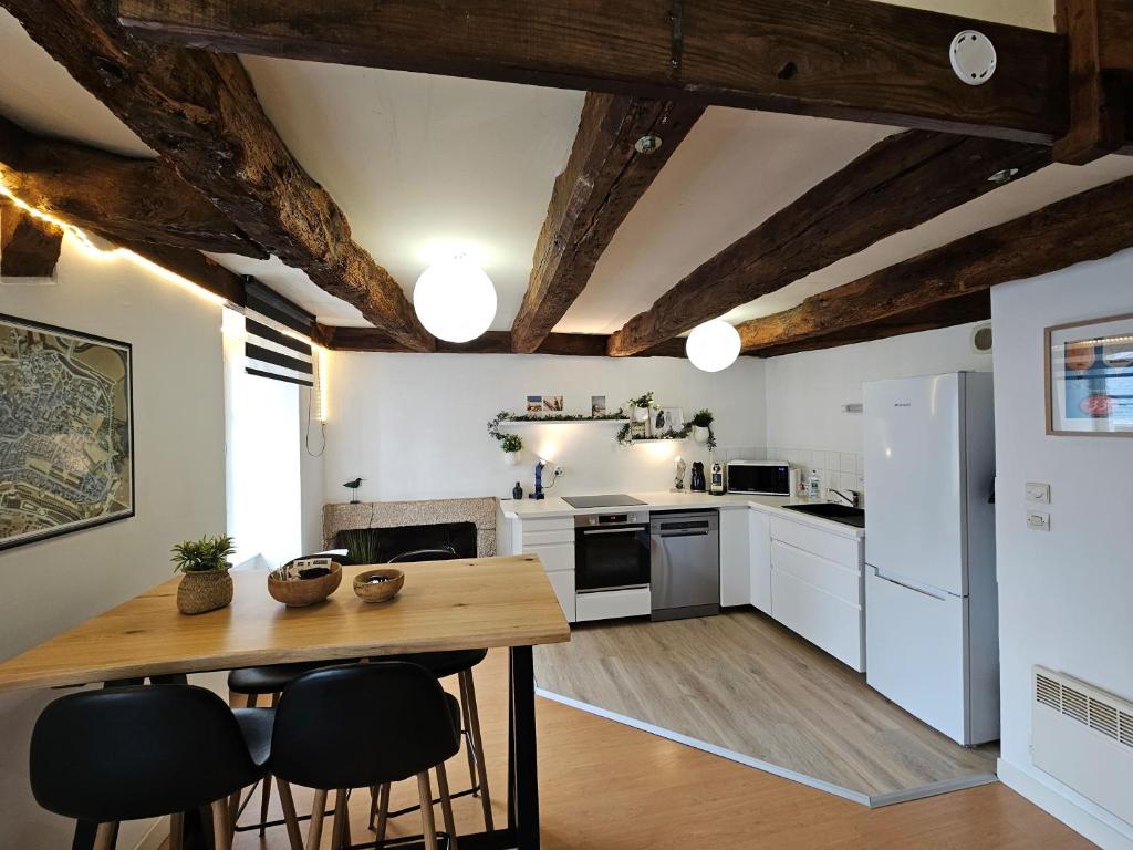 - une cuisine avec des appareils blancs et une table en bois dans l'établissement Duplex au coeur de Dinan, à Dinan