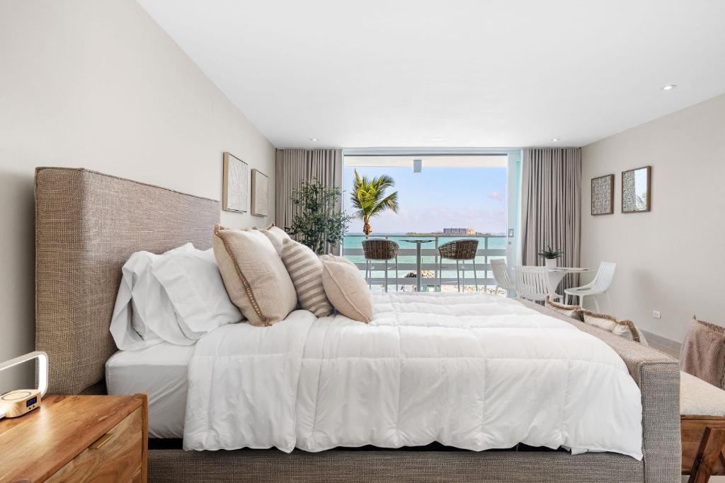 Un dormitorio con una gran cama blanca y una mesa en Your Ocean Zen Oasis, en Fajardo